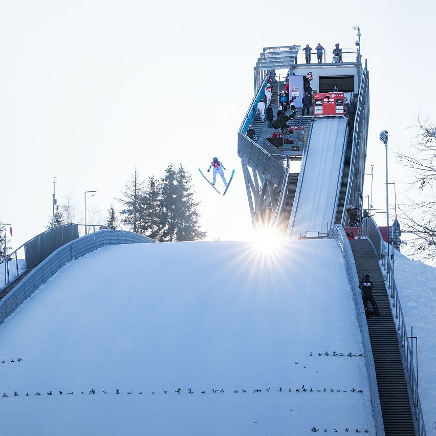 Nordic Combined Triple Seefeld 2025_Skispringer mit Schanze und Sonnenstern