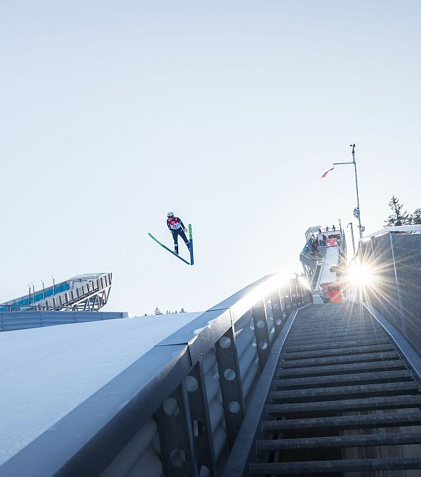 Nordic Combined Triple Seefeld 2025_Skispringer in der Luft mit Sonnenstern