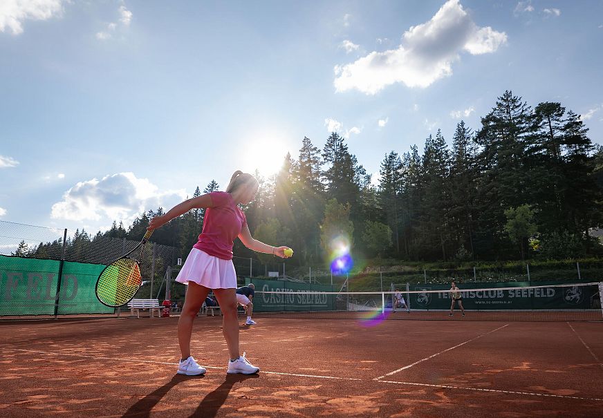 Tennis in Seefeld - Außenanlage - Doppel - Frau kurz vor Aufschlag - Aufnehme gegen die Sonne