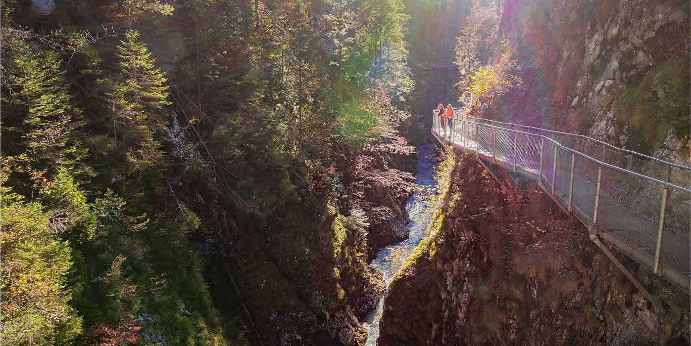 Geisterklamm im Herbst_Drohnenaufnahme_zwei Frauen auf dem Steg mit Flusslauf