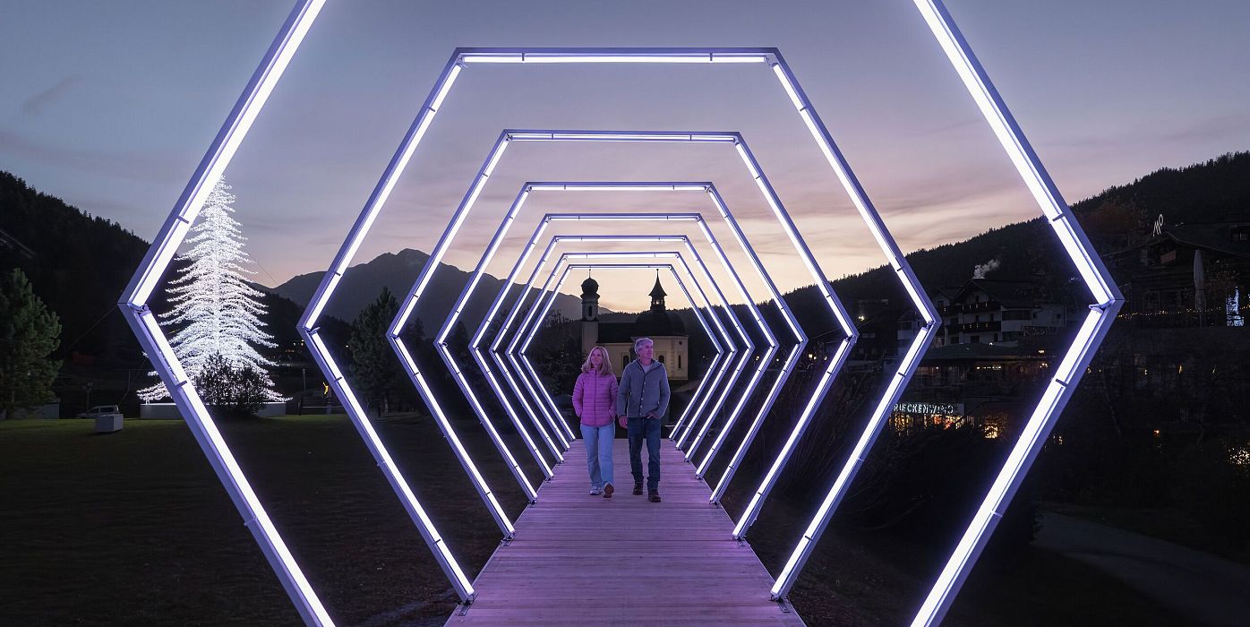Lichterpark Seefeld_2024_Mann und Frau laufen durch Lichtertunnel_Weitwinkelaufnahme