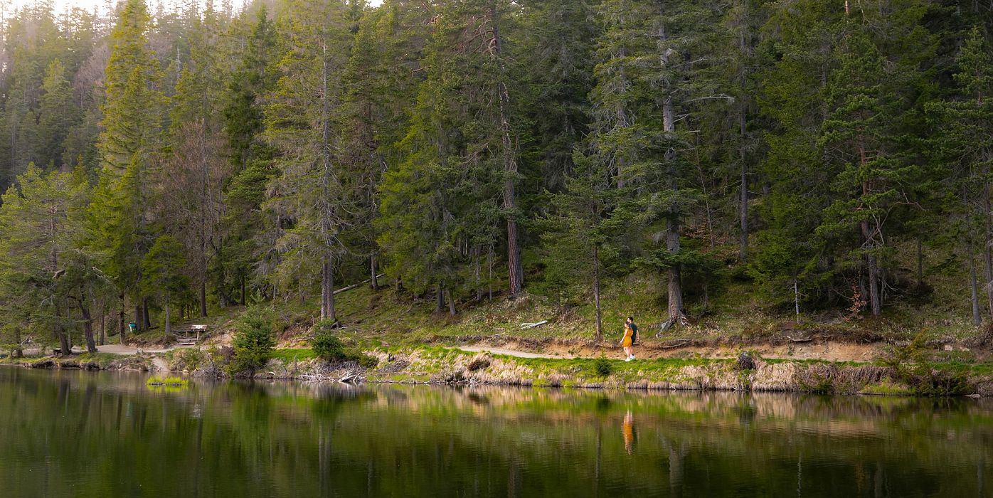 Möserer See im Frühling - Paar läuft entlang des Sees Aufnahme von weit weg