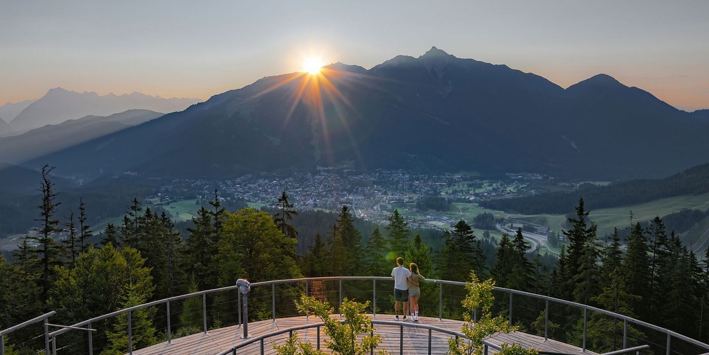 Sonnenaufgang Aussichtsplattform Bruschkopf - Drohnenaufnahme - Paar steht am Geländer der Plattform - Sonnenstern über Seefelder Spitze