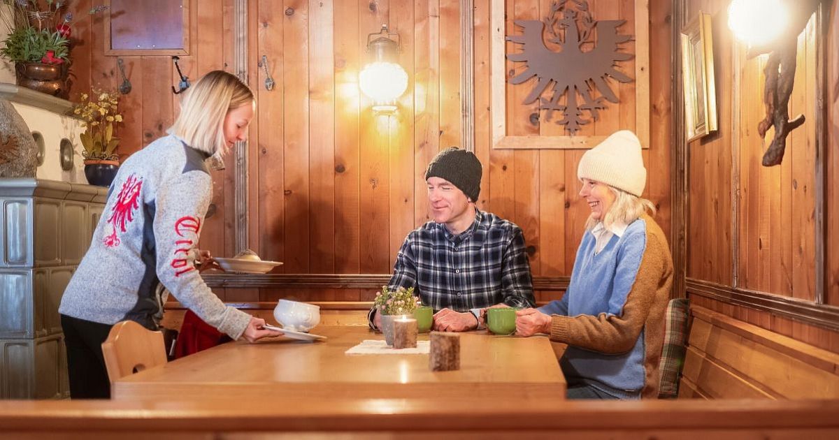 Winterwandern im Wildmoos_Paar kehrt ein in der Lottenseehütte_Paar bekommt Essen