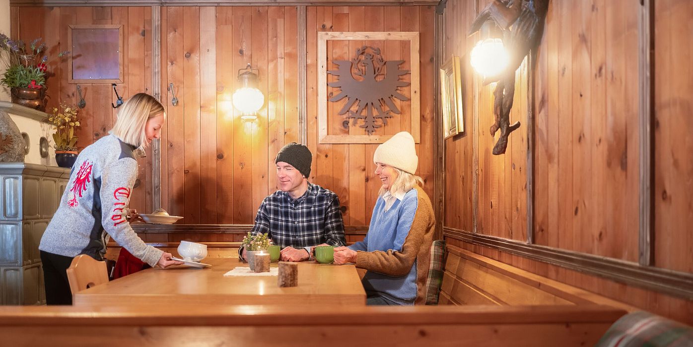 Winterwandern im Wildmoos_Paar kehrt ein in der Lottenseehütte_Paar bekommt Essen