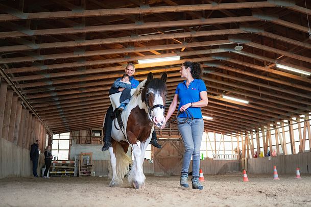Arche Herzensbrücken_Carola Mitteregger mit Kind auf Pferd
