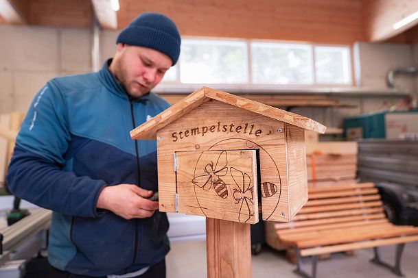 Bau der Stempelstellen im Bauhof Leutasch_Stempelstelle mit Bauhof Mitarbeiter im Hintergrund