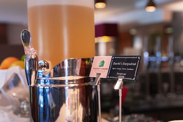 A chilled drink in a silver bucket with a card labeled "Beverly's Energizer" nearby.
