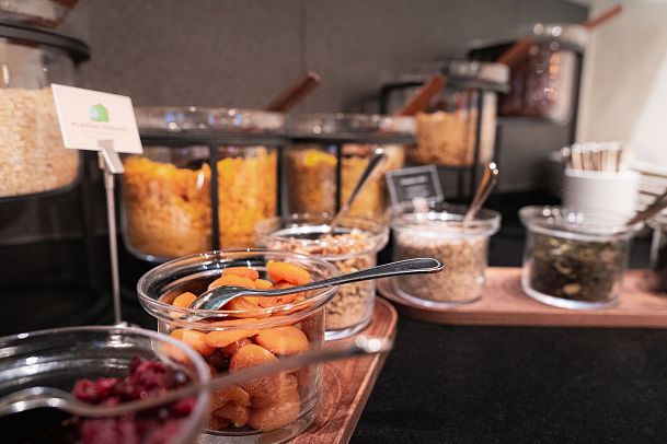 A buffet display with jars of grains, dried fruits, and nuts arranged neatly.