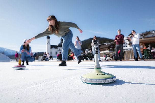 eisstockschiessen-in-seefeld-fokus-auf-eisstock-mit-menschen-im-hintergrund-1