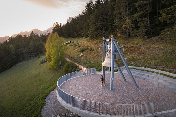 Friedensglocke Mösern zur Sonnenuntergangsstimmung im Frühling - Drohnenaufnahme Paar unterhalb der Glocke
