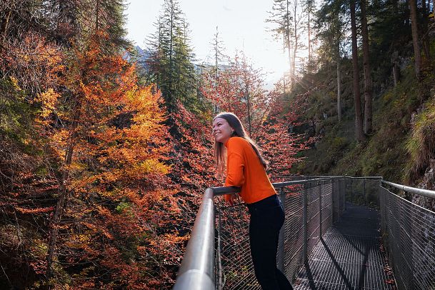 geisterklamm-im-herbst-frau-steht-auf-dem-steg-und-lacht-8