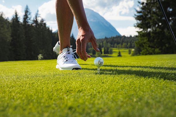 Golfen im GC Wildmoos im Sommer_Nahaufnahme Golfer legt Ball auf Abschlagspunkt