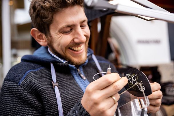 Handwerksfest in Seefeld - Lachender Handwerker bei Federkiel-Stickerei