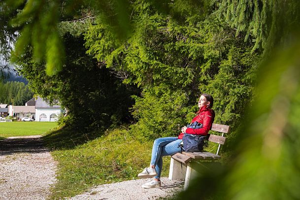 Hofladenrunde Leutasch - Frau genießt die Sonne neben Wanderweg