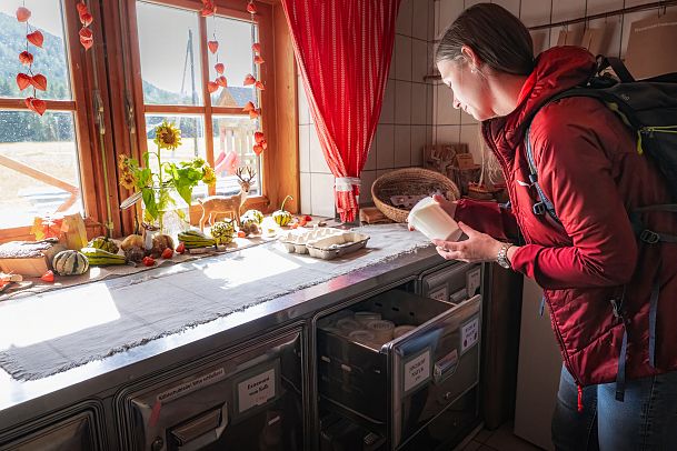 hofladenrunde-leutasch-frau-schaut-sich-joghurt-an-im-hofladen-thoamlhof-1-2