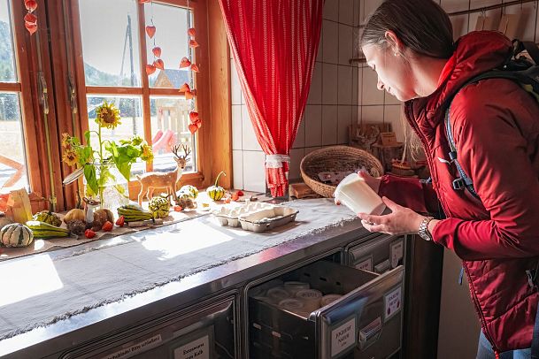 Hofladenrunde Leutasch - Frau schaut sich Joghurt an im Hofladen Thoamlhof