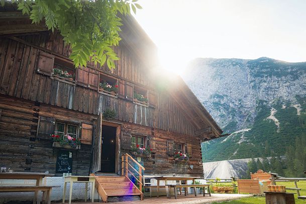 Kastenalm im Sommer_Sonne blitzt an Alm vorbei