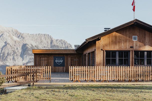 Ein Holzhaus mit Veranda und Blick auf die Berge.