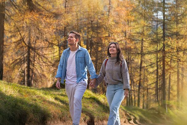laerchenwald-in-reith-portrait-paar-laeuft-durch-den-wald-und-staunt-36