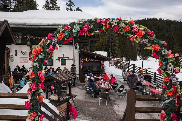 Langlaufen im Wildmoos - Einkehr in der Wildmoosalm Blumenkranz vor der Hütte Hochformat