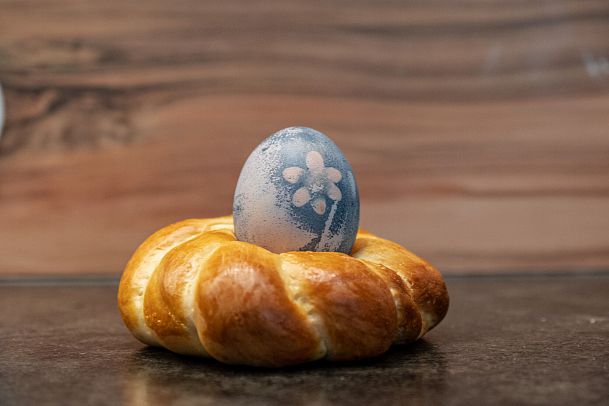 A braided pastry with a decorated blue egg on top.