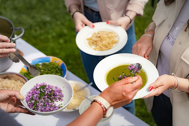Leutascher Bergfrühlingstage 2025_Wildkräuterwanderung Hungrig auf Natur am Wirtseppelerhof_Blumen werden auf Suppe gestreut