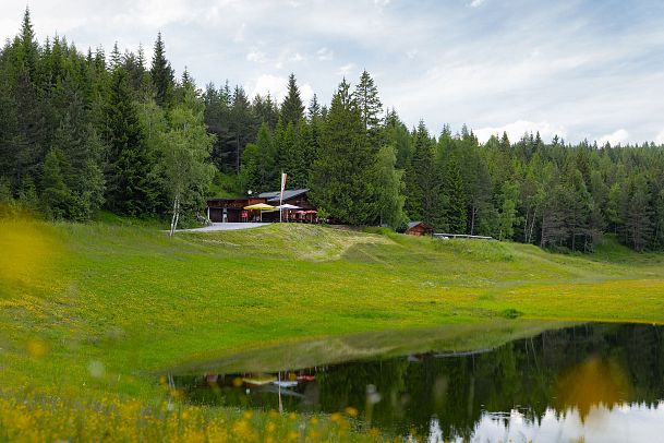 Lottensee im Frühsommer - Lottenseehütte mit verschwommenen Blumen im Vordergrund