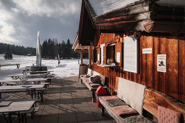 Muggenmoosalm Nahaufnahme Bänke und Alm von der Seite