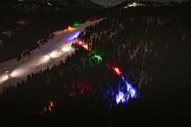 Verschneite Hänge in der Region Seefeld bei Nacht mit bunten Lichtern. Skifahren im Winter.