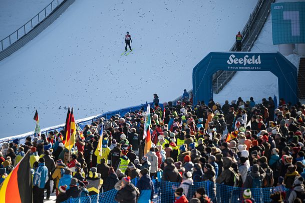 nordic-combined-triple-2023-fans-mit-skispringer-im-auslauf-5