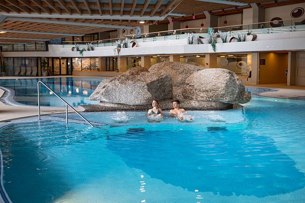 olympiabad-seefeld-mann-und-frau-sitzen-im-schwimmbad-jacuzzi-und-blicken-hinaus-1