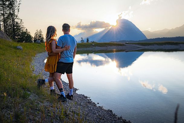 Paar am Gschwandtkopf Speichersee blickt auf Hohe Munde bei Sonnenuntergang
