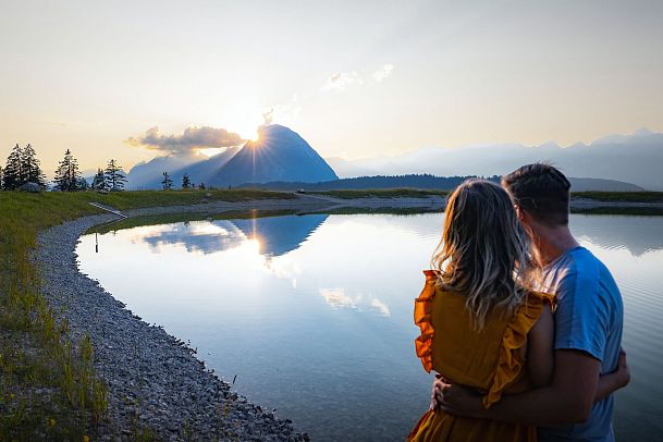 Paar genießt Sonnenuntergang am Gschwandtkopf Speichersee