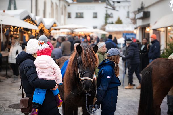 ponyreiten-am-seefelder-weihnachtsmarkt-mutter-mit-kind-schauen-auf-pony-1
