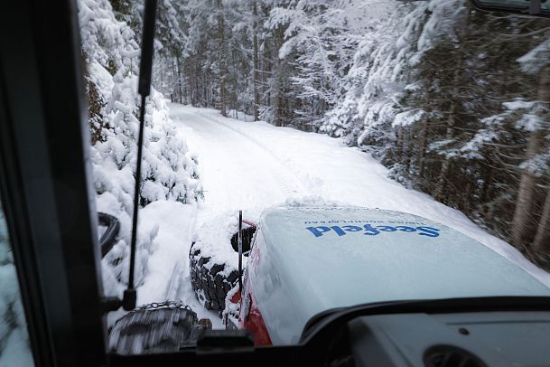 Schneepflug räumt verschneiten Waldweg in der Region Seefeld.
