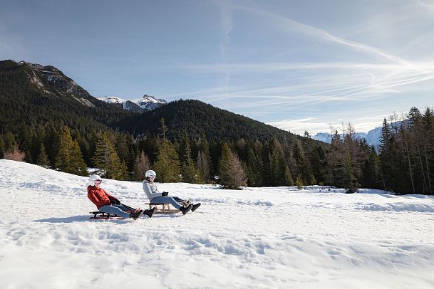 Rodeln im Gaistal_zwei Frauen auf der Abfahrt von der Hämmermoosalm