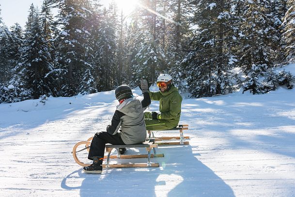 Rodeln in der Region Seefeld - Vater mit Sohn - High Five