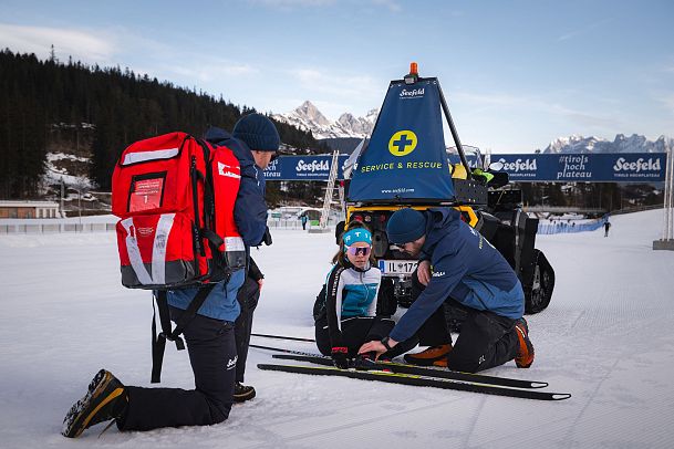 Seefeld Loipenservice - Erste Hilfe Langläuferin gestürtzt Helfer mit großem Erste Hilfe Rucksack
