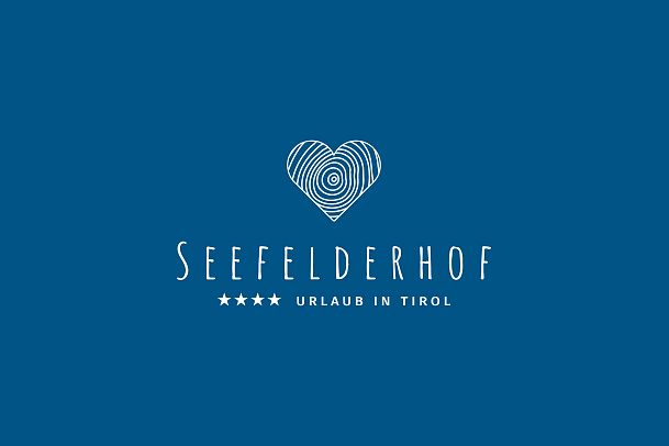 Logo of Seefelderhof with a blue background and a heart design.