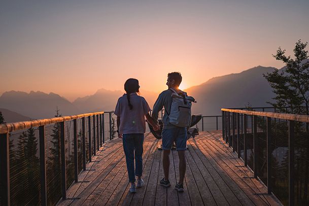 Sommerurlaub in der Region Seefeld - Paar schaut sich den Sonnenaufgang an auf der Aussichtsplattform Brunschkopf - 8