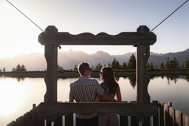 Sonnenuntergang am Kaltwassersee_Paar steht vor Bilderrahmen und schaut sich an
