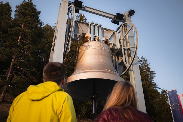 Sonnenuntergang an der Friedensglocke - Paar blickt hinauf zur Glocke im Detail