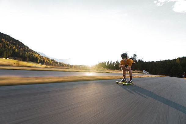 sportler-auf-der-abfahrt-auf-skirollerstrecke-beim-sonnenuntergang-im-herbst-seefeld-1