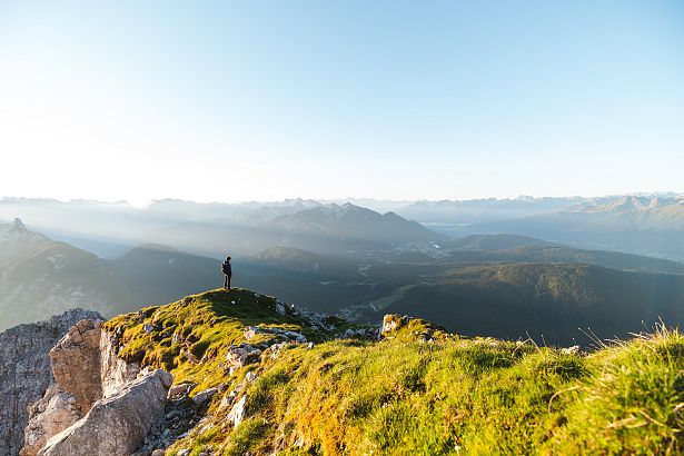 wanderer-auf-der-gehrenspitze-im-sonnenaufgang-blick-auf-die-region-seefeld-panoramaaufnahme-1