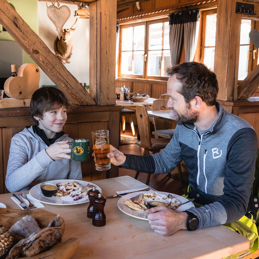 Ein Mann und ein Junge stoßen in einer rustikalen Gaststätte an.