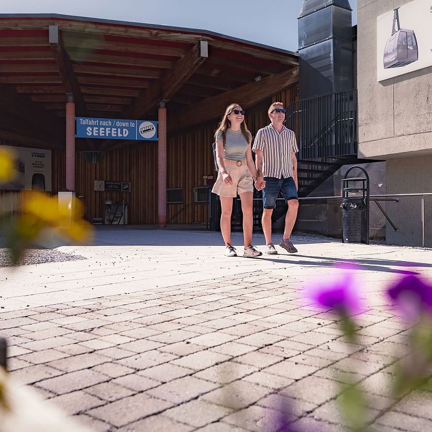 Paar läuft vor Rosshütte Mittelstation im Sommer