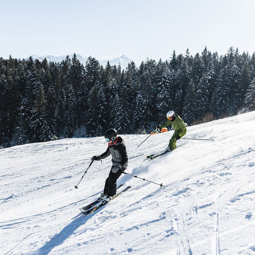 Skifahren - Papa und Sohn zusammen auf der Piste