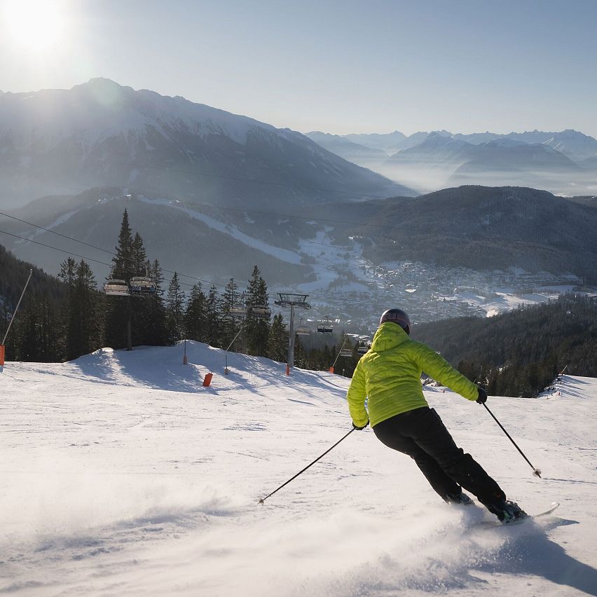 Skifahrerin an der Rosshütte - Skifahrerin am carven mit Lift und Sonne
