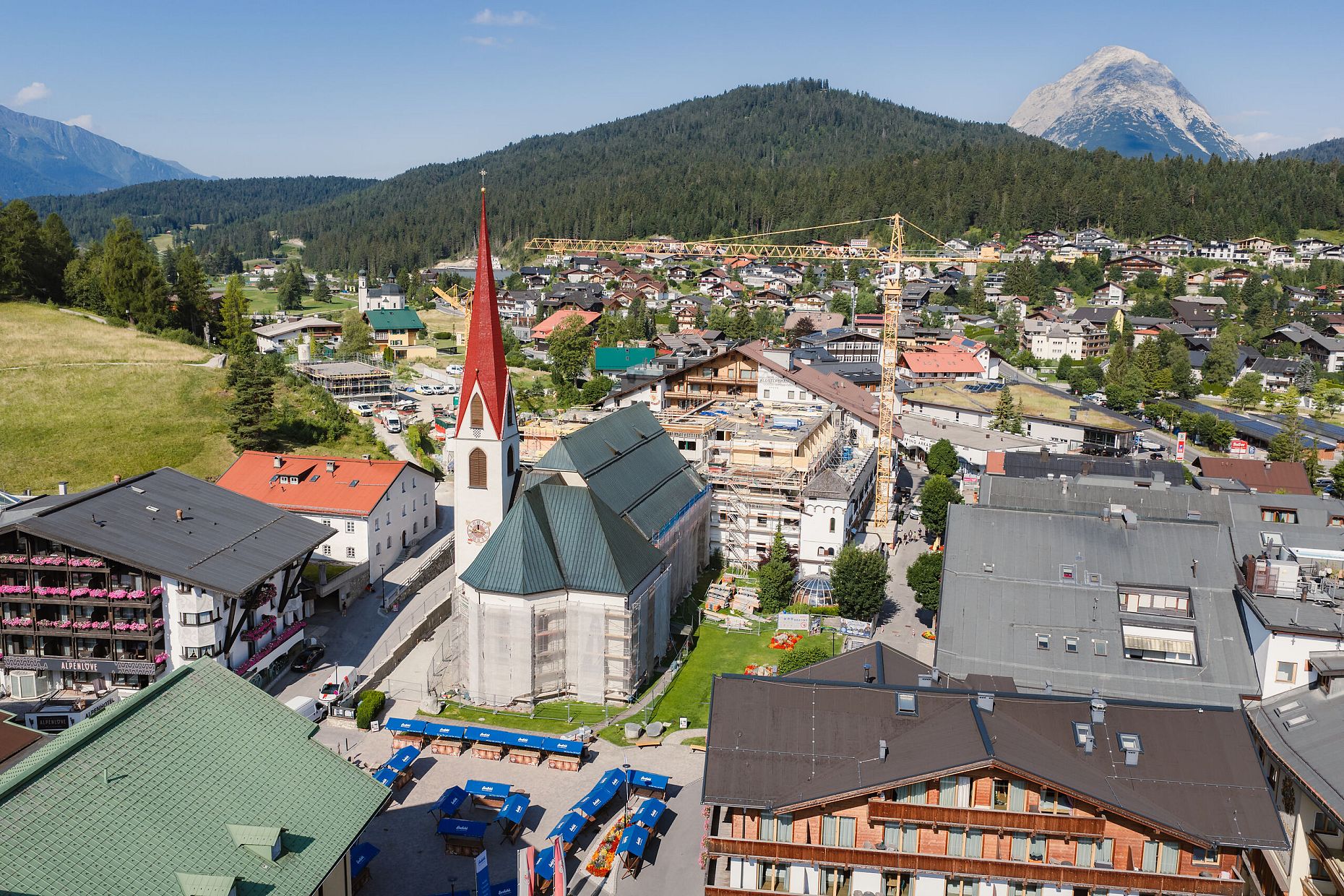 Luftaufnahme von Seefeld mit verschiedenen Gebäuden, einem Kirchturm und umliegender Landschaft.